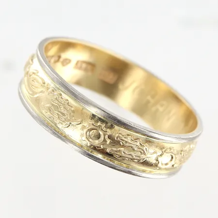 Ring mönstrad stl:21¼ bredd 6mm, vitguld/gulguld, gravyr, 18K. Vikt: 6,1 g på auktion i Malmö Triangeln hos Pantbanken Sverige