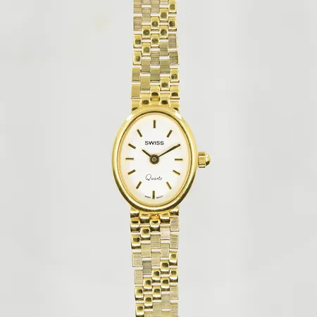 Damur Swiss 18K quartz boett 20x16 mm, längd inklusive ur 18½ cm, integrerad länk, länkens bredd 6-10 mm, personlig gravyr på boett, behov av batteribyte, 18K. Bruttovikt 20,0g