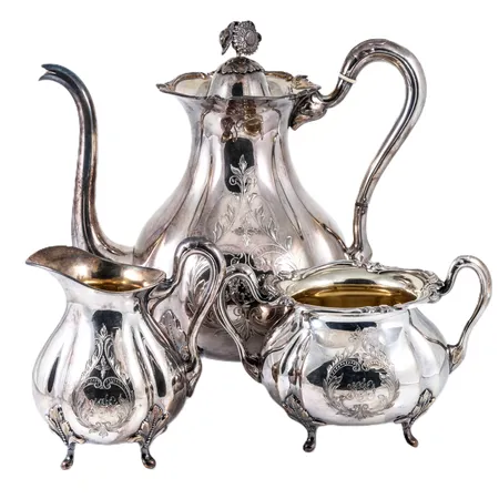 Kaffeservis i silver: kaffekanna c:a 26cm hög, gräddkanna c:a 12,5cm hög, sockerskål c:a 12cm hög. Monogramgravyr på samtliga. De väger tillsammans 1270,0g.