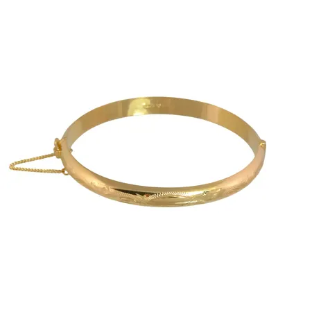Armring i 18K guld, delvis mönstrad, oval form, öppningsbar, Örns Juvelatelje, Göteborg 1968, svensk kontrollstämpel, inre omkrets 18,0 cm, bredd 7 mm, tjocklek 3 mm, fint skick, gravyr (initialer och årtal) på skenans insida Vikt: 13,1 g