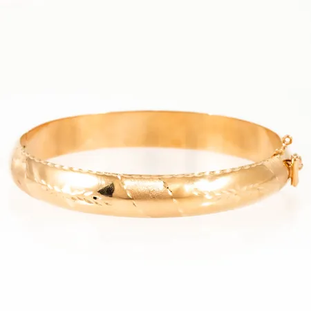 Armring med graverad mönsterdekor innermått 20cm (öppningsbar), bredd 10mm, öglor för säkerhetskedja finns, men inte kedja, 18K 18,2g. 