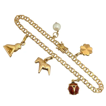 Armband Bismarck med fem berlocker i 18K guld, Guldsmedjan Hilden Holger (GHH), svensk kontrollstämpel, längd knäppt 19,0 cm, bredd 4 mm, berlocker med varierande mått Vikt: 9,6 g