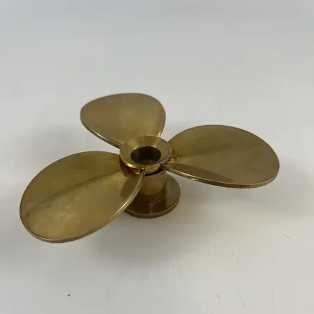 Ljusstake Skultuna, formgivare Pierre Forssell 1970-1980-talet, propeller, höjd 3cm, bredd ca 10cm, mässing.