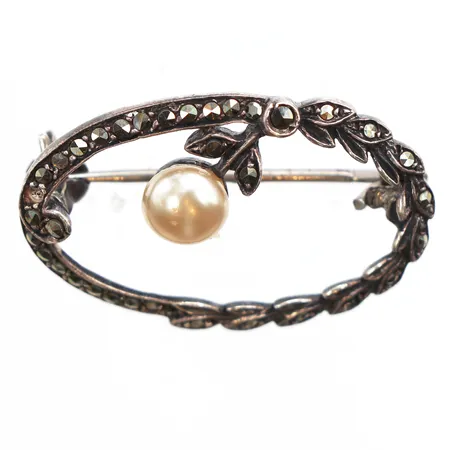 Brosch med markasiter och pärla, längd 18,3mm, bredd 28,4mm, pärla Ø 6mm, något ojämn, 830/1000 silver. Vikt: 3,2 g