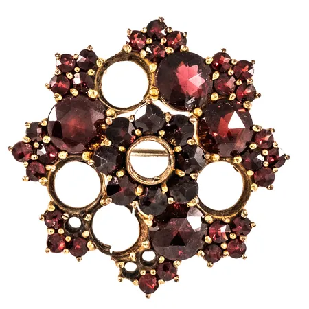 Brosch med granater Ø29mm, 29st ca Ø2,3mm, 8st ca Ø3,1mm, 4st ca Ø5,9mm, stenar kan användas som reserv, stämplad GERMANY, flera stenar saknas, gulmetall 5,4g.