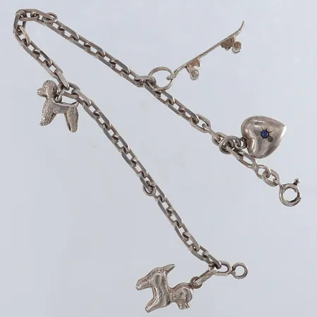 Armband med fyra berlocker längd 18cm bredd 3,6mm två öglor saknar berocker silver 835/1000 Vikt: 11,1 g
