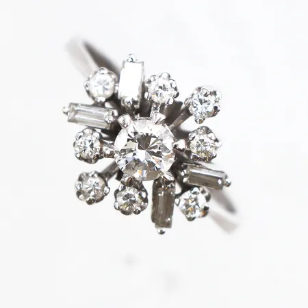 Ring med brilljantslipad diamant, 1x ca 0,39ct ca W/SI samt 8st briljantslipade och 4st baguettslipade ca 0,45ctv, stl:18½, bredd 2,6-13,7mm, vitguld, etui, 18K. Vikt: 5,2 g