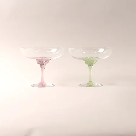 Ett par champagnekupor "Sugar Dandy", Åsa Jungnelius för Kosta Boda, grön och rosa fot, höjd 12cm, glas.