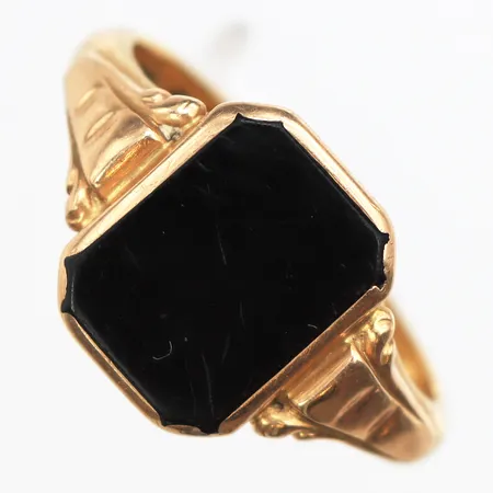 Klackring med onyx, stl:20½, bredd 3,4-14,7mm, ojämn form, skev skena, gravyr, skena i 23K, infattning kring sten 18K. Vikt: 8,6 g