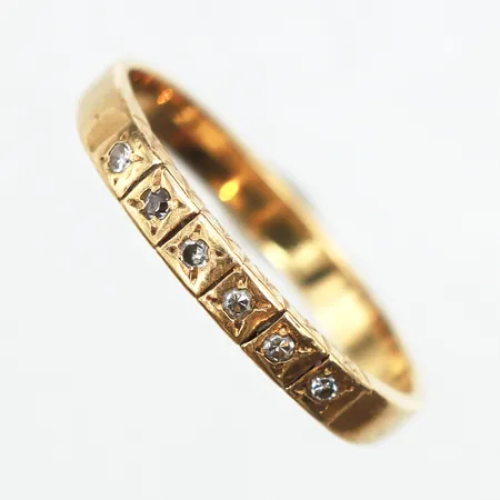 Ring med 6 diamanter 0,06ctv enligt gravyr, stl:16¾, bredd ca 2,5, 18K. Vikt: 2,4 g