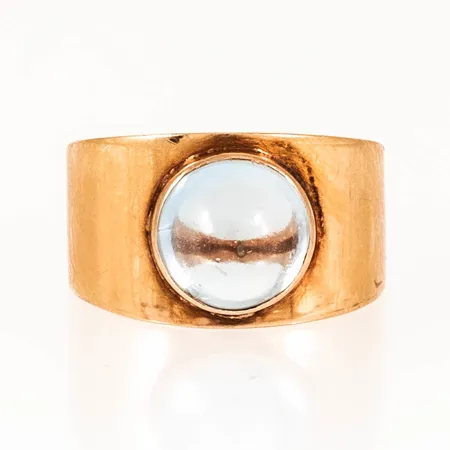 Ring med en cabochonslipad ljusblå sten stl:16¾ bredd 4,5-10,5mm, 18K 2,9g. 