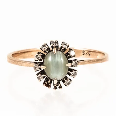 Ring cabochonslipad grå/grön sten med kattöga effekt och 10 x ca 0,005ct 8/8-slipade diamanter stl:18¼ bredd 2-9,5mm, två diamanter saknas, 14K 1,6g.  
