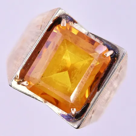Klackring med orange stl:17½ bredd 3-14 mm 18K. Vikt: 7,8 g