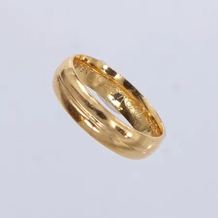 Ring slät, stl: 17¼, bredd 5mm, gravyr, 18K.  Vikt: 4,6 g