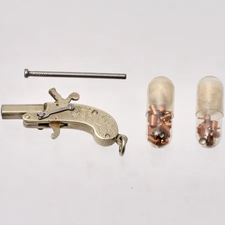 Hänge i metall, Pistol, mått 18,4x43,7mm, tillverkad i Österike, tillbehör skott och laddstav.