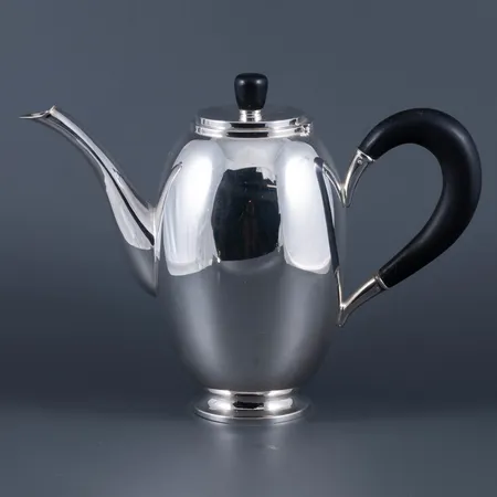 Trevlig serveringskanna i silver med träskaft och träknopp. Den är ca 16 cm hög och väger 353,5g bto. Stämplad 835WTB 320 svensk kontrollstämpel S.