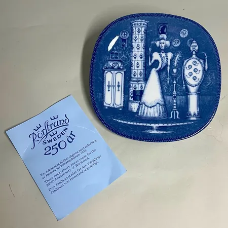 Jubileumstallrik Rörstrand 250 år 1726-1976 "Adertonhundratalet", Dekor Niels-Christian Hald, 19,5cm x 19,5cm, hål på baksidan för upphängning, Original kartong och infoblad 