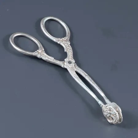 Småkakstång i silver (830/1000). Den är 105 mm lång och väger 18,5g. Glapp i gångjärnet men fungerar.