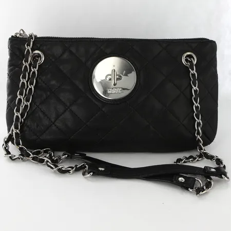 Väska DKNY svart skinn med detaljer i vitmetall, innerficka med dragkedja, 16x28cm, bruksslitage Skickas med paket.