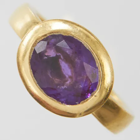 Ring med en oval ametist ca.10x8mm, Ø18¼, bredd: 3,6-12mm, 18K Vikt: 9,3 g