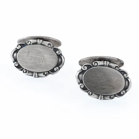 Ett par manschettknappar i silver. De är 21 x 14,5 mm och väger 8,0g. Stämplad X8 (1948), GD&Co (Guldvaruaktiebolaget G. Dahlgren & Co AB, Malmö), silver och kattfot.