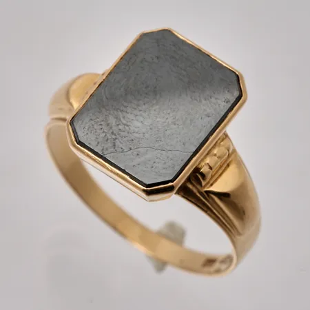 Klackring i 18K guld, stl 19¾, bredd 2,3-14,3mm, 1st Hematit, mått 10,4x13,4mm, Guldvaruhuset Aktiebolag, år 1956, vikt 4,67g.