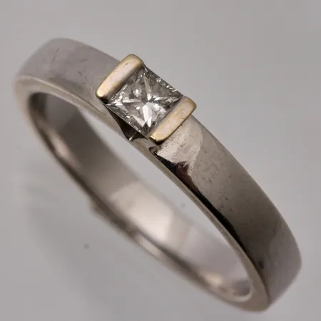 Ring i 18K vitguld, stl 18, bredd 3,2-3,5mm,1st prinsesslipad diamant, mått 3,2x3,2mm, totalt 0,20ct, vikt 5,25g.