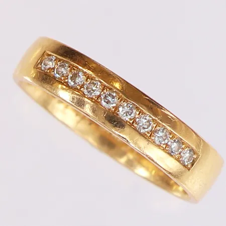 Ring med briljantsslipade diamanter 10 x 0,02ct, totalt 0,20ctv, stl: 19¼, bredd 4,8mm, gravyr, 18K.  Vikt: 5,6 g