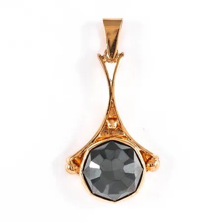 Hänge i 18K guld med en fasetterad hematit. Det är 2 - 20 mm brett, 43 mm långt inkl. ögla och väger 11,8g.