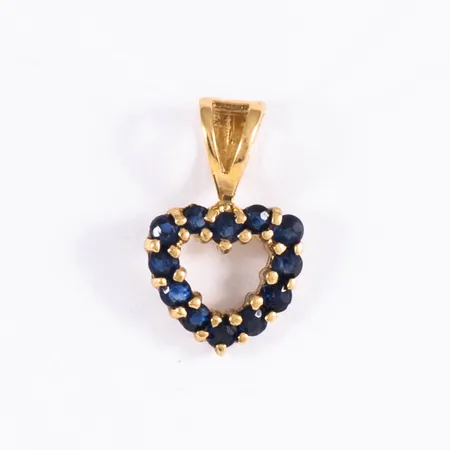 Hänge i 18K guld: Genombrutet hjärta med tolv blå safirer Ø 1,5 mm. Det är 8 mm brett, 13 mm långt inkl. ögla och väger 0,6g.