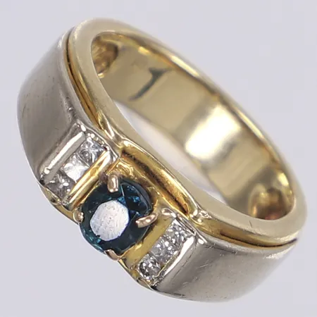 Ring med diamanter 5x prinsesslipade ca 0,01ct, 1x briljantslipad ca 0,01ct samt blå syntetisk sten, stl 20, bredd 6-8mm, mittsten troligen utbytt, en diamant utbytt från prinsesslipad till briljantslipad samt naggad, vitguld/rödguld 14K Bruttovikt: 9,7g Vikt: 9,7 g