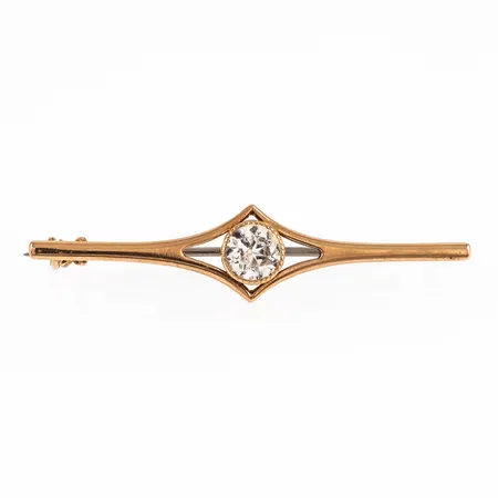 Brosch i 14K guld med vit sten. Det är 46 x 10,5 mm och väger 2,1g. Nål i metall.