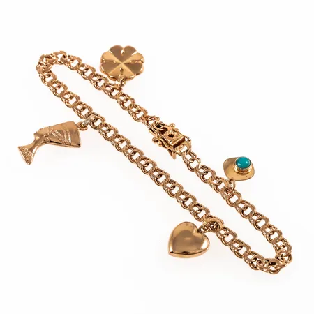 Armband Bismarck i 18K guld med fyra berlocker: Fyrklöver, Nefertiti, hjärta. Det är 19 cm långt, 4 mm brett och väger 9,2g. Kistlås.