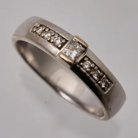 Ring i 18K vitguld, stl 18¼, bredd 4,6mm, 7st diamanter, 1st prinsesslipad, mått 2,5x2,5mm, totalt 0,20ct, tillverkad av Guldfynd, vikt 5,3g.
