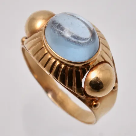 Ring i 18K guld, stl 18½, bredd 2,6-12,3mm, 1st blå sten, mått 8x10mm, tillverkad av Ceson Guldvaru Ab, år 1956, bruttovikt, 4,18g, ca nettovikt 2,7g.