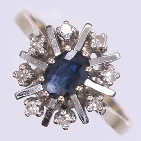 Carmoséring med diamanter 8x ca 0,02ct samt blå sten troligen safir stl:18¾ bredd 3-14mm, spår från storleksändring, spricka i skena, vitguld 18K Vikt: 4,7 g