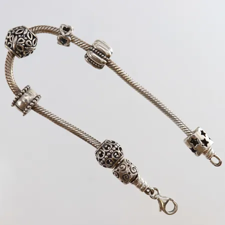 Armband med sju berlocker längd 19cm bredd 2,8mm Silver 925/1000.  Vikt: 28,1 g