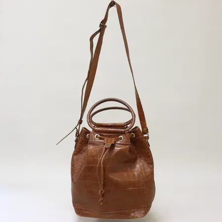 Väska Aigner axelrem 142cm, rundade handtag, präglat läder i brunt, detaljer och beslag i gulmetall, ca 25x31x17cm, utvändigt slitage på bottens hörn samt på fäste till axelrem, fläckar invändigt, inga tillbehör.