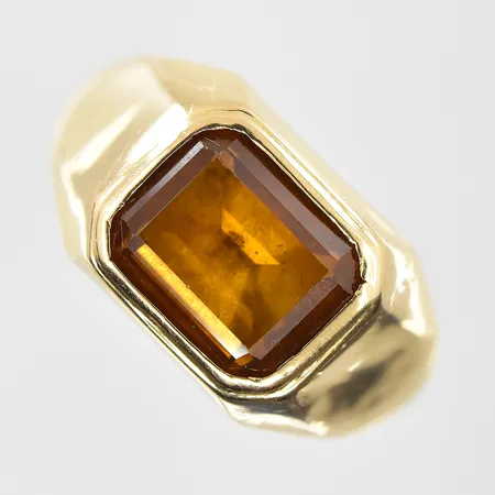 Ring med brunorange sten stl:20¼, bredd 3-11 mm, något lös sten, 18K. Vikt: 4,6 g