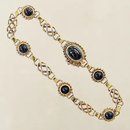 Armband med blå syntetiska safirer en av safirerna med mindre effekt av asterism längd 17cm bredd 5-12mm 18K Vikt: 11,2 g