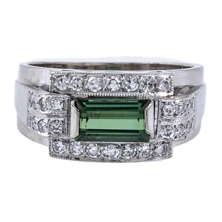 Ring med en baguettslipad grön turmalin ca 7,3x4,1mm, 16 x ca 0,01ct och 14 x ca 0,02ct 8/8-slipade diamanter stl:16 bredd 3,8-8,7mm, vitguld 18K 7,0g.