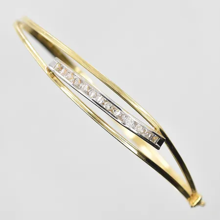 Armring med vita stenar stl:65x55 mm, bredd 3-10 mm, öppningsbar, gulguld/vitguld, 14K. Vikt: 5,4 g