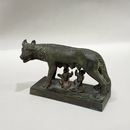 Skulptur "Den Kapitolinska Varginnan" troligen italiensk souvenir från andra halvan av 1900-talet höjd 6,5cm längd ca 8,7cm brons, lätt bruksslitage