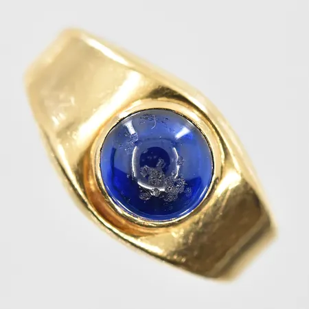 Ring med blå sten stl:17½, bredd 3-10 mm, sliten sten, skev samt krackelerad skena, 18K. Vikt: 4,6 g