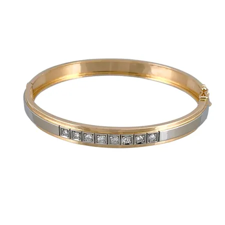 Armring i 18K guld, öppningsbar oval modell, dekor i vitguld på främre delen av armringen, Diamanter 8 st totalt 0,40ct - graverat på skenans insida, Ceson Guldvaru Ab (K&EC), svensk kontrollstämpel, inre omkrets 18,0 cm, skenans bredd 7 mm, liten ojämnhet på armringens bakre del, fint skick Vikt: 16,6 g