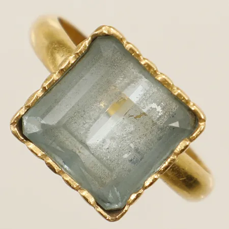 Ring med akvamarin stl: ca18 bredd 14mm, skev gravyr, infattning på sten i 18K skena i 23K bruttovikt: 10,2g Vikt: 10,2 g