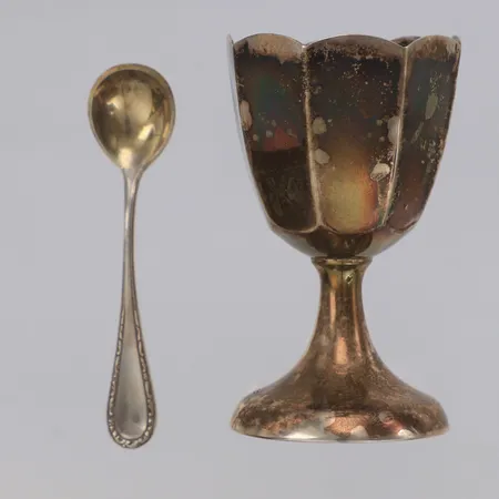 Äggkopp på fot med fasetterad dekor, höjd 6,5cm, saltsked, längd 7cm, 830/1000 silver Vikt: 28,4 g