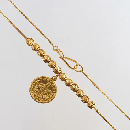 Collier med kulor och intrigerat mynt längd 46cm bredd 0,7-27mm 21K. Vikt: 7,8 g