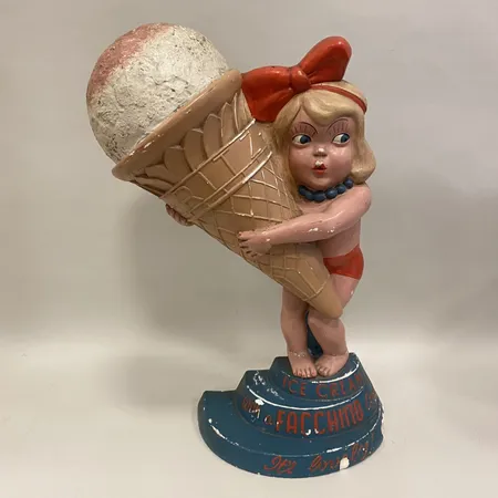 Reklamskulptur, flicka med glass, höjd ca 50cm, text: Ice cream with a Facchino", skador, bitar lossnat Vikt: 0 g Specialfrakt, kontakta pantbankskontoret för mer information.