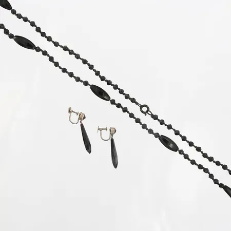 Set med sorgesmycken, collier samt örhängen i svart pressglas, collier längd 175cm, örhängen med höjd 35mm, skruvsystem, 1900-talets första hälft, silver Vikt: 0 g